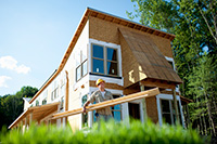 Construction worker outside home in the process of being built