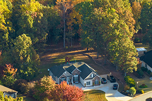 Suburban home surrounded by mature trees cared for by tree service Smithville professionals at Ben Bivins Tree Experts