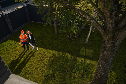 Tree service Smithville professional & homeowner discussing trees in the yard